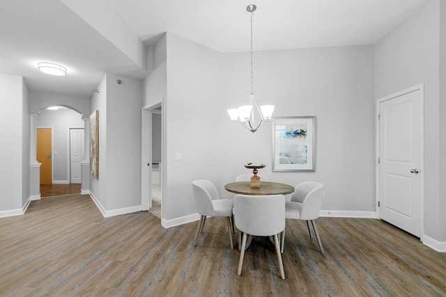 dining space with light hardwood / wood-style floors and a notable chandelier