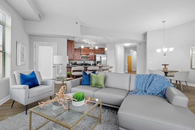 living room featuring a healthy amount of sunlight, hardwood / wood-style floors, and an inviting chandelier