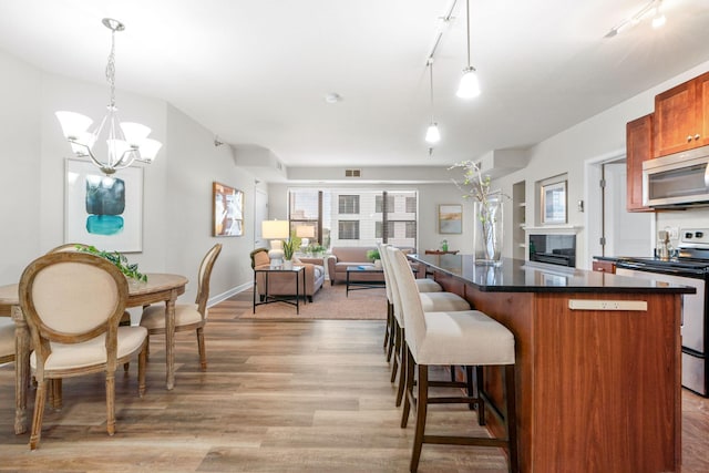 kitchen featuring a notable chandelier, decorative light fixtures, track lighting, and stainless steel appliances