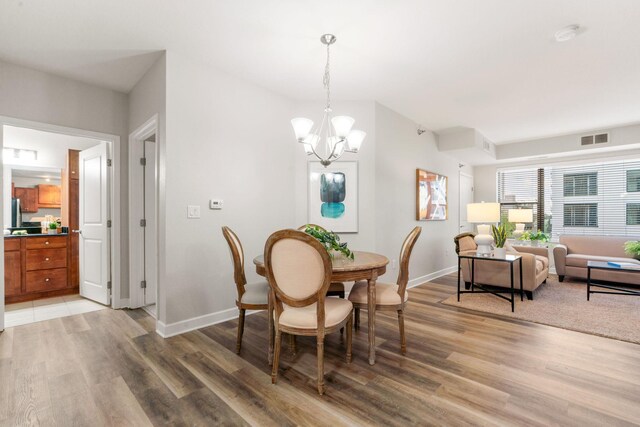 dining space featuring hardwood / wood-style floors and an inviting chandelier