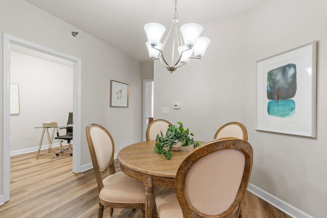 dining area featuring an inviting chandelier and light hardwood / wood-style flooring