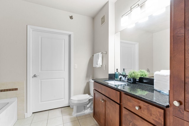 bathroom featuring tile patterned flooring, vanity, a tub, and toilet