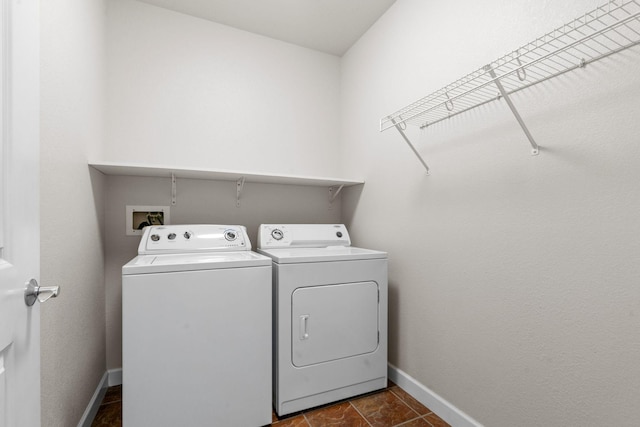 laundry area with washer and clothes dryer and dark tile patterned floors