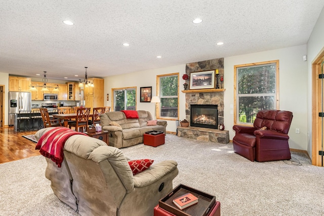 living room with a stone fireplace and a textured ceiling