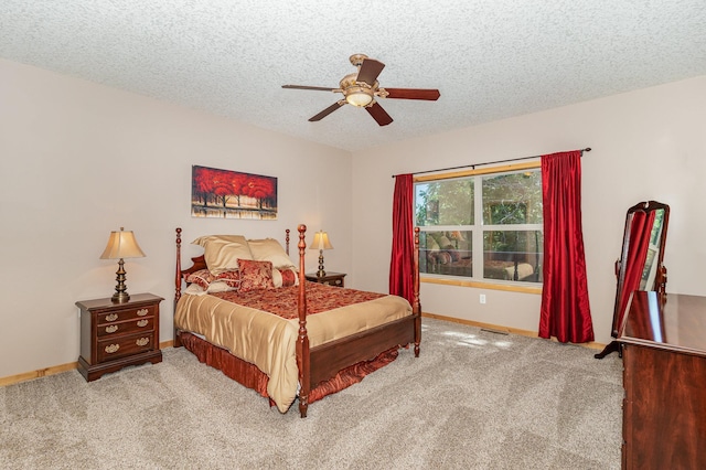 bedroom featuring ceiling fan, carpet floors, and a textured ceiling