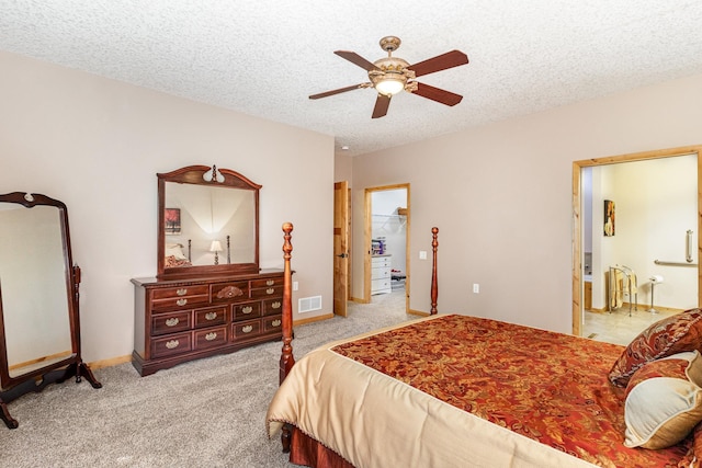 carpeted bedroom featuring ceiling fan, a spacious closet, and a textured ceiling