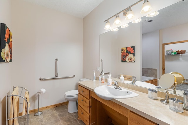 bathroom with vanity, a textured ceiling, a bathing tub, and toilet