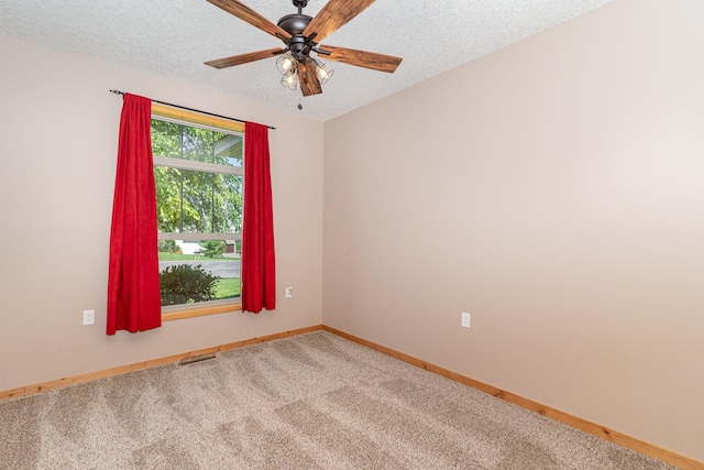 carpeted spare room with ceiling fan and a textured ceiling