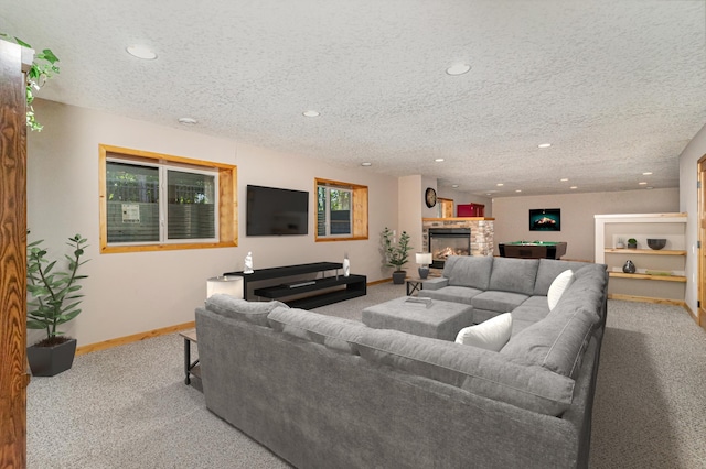 carpeted living room featuring a fireplace and a textured ceiling