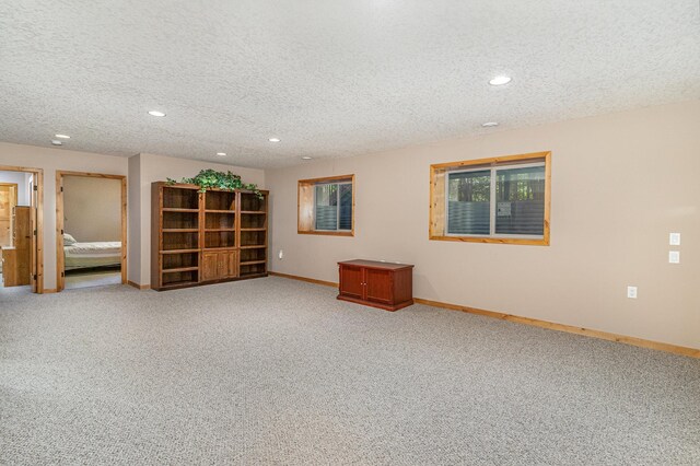 spare room featuring carpet and a textured ceiling