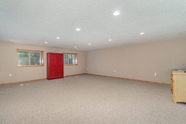 carpeted empty room with sink and a textured ceiling