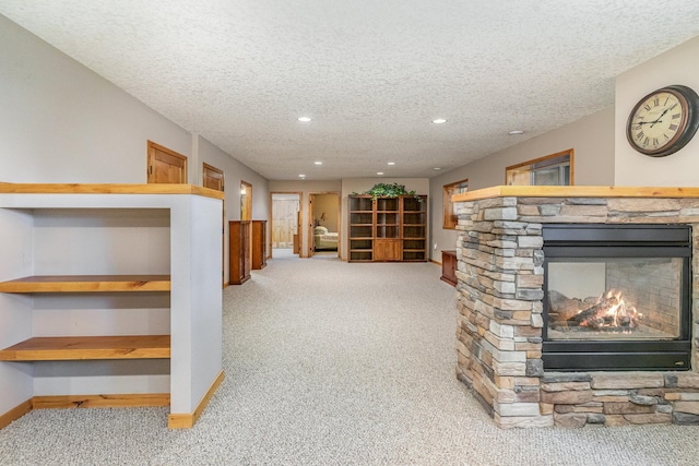 interior space featuring a fireplace, light carpet, and a textured ceiling