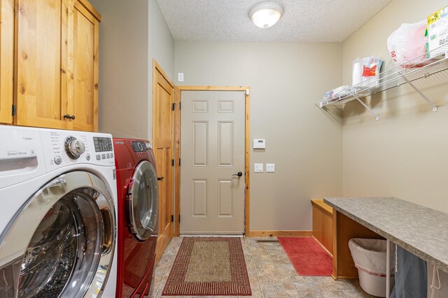 washroom with washer and dryer, cabinets, and a textured ceiling