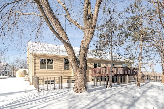 snow covered property with a wooden deck