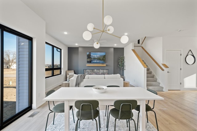 dining space with a notable chandelier and light hardwood / wood-style flooring