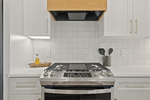 kitchen featuring gas stove, ventilation hood, white cabinetry, and backsplash