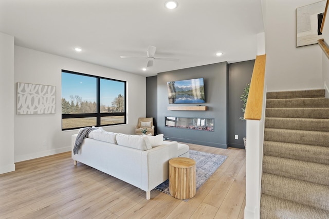 living room featuring light hardwood / wood-style floors and ceiling fan