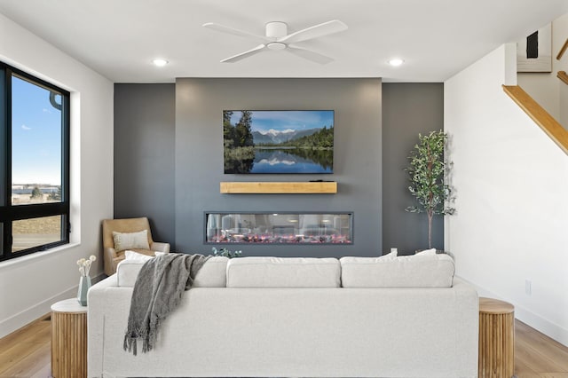 living room featuring light hardwood / wood-style flooring and ceiling fan