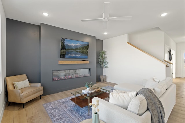 living room featuring ceiling fan and light hardwood / wood-style flooring