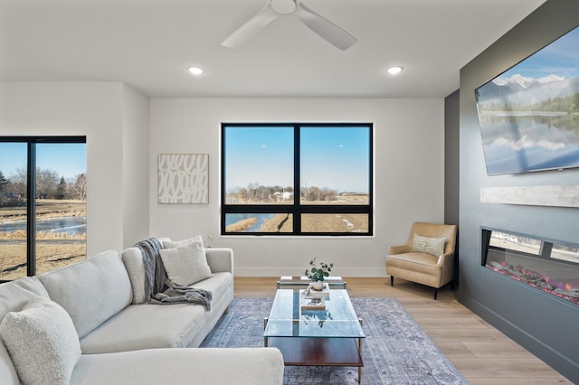 living room featuring light hardwood / wood-style flooring and ceiling fan