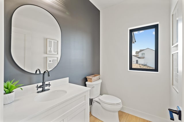 bathroom with vanity, wood-type flooring, and toilet