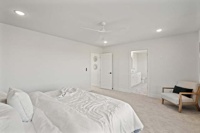 carpeted bedroom with ceiling fan and ensuite bath