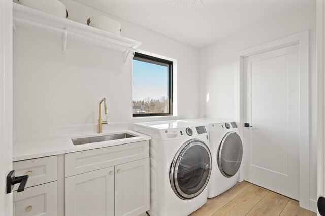 laundry room featuring cabinets, washing machine and dryer, and sink