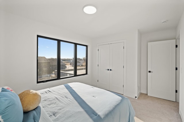 bedroom featuring light colored carpet and a closet