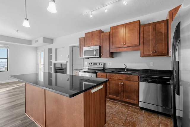 kitchen with hanging light fixtures, a center island, appliances with stainless steel finishes, and sink