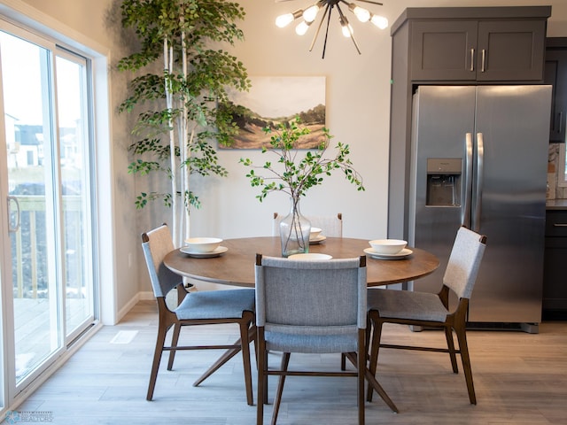 dining room featuring a notable chandelier and light wood-type flooring