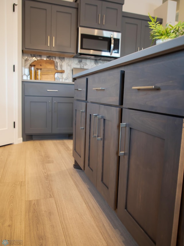 kitchen with gray cabinetry and light hardwood / wood-style floors