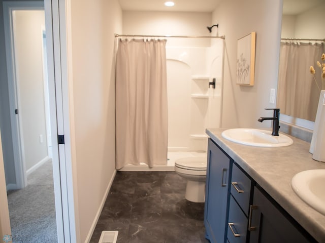 bathroom featuring vanity, toilet, and walk in shower