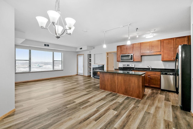 kitchen with stainless steel appliances, dark hardwood / wood-style flooring, hanging light fixtures, and a kitchen island