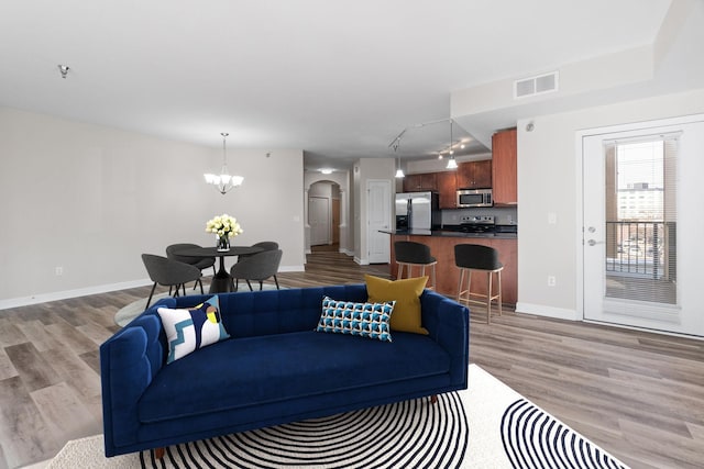 living room with a chandelier and light hardwood / wood-style floors