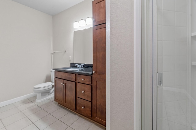 bathroom featuring tile patterned flooring, vanity, a shower with shower door, and toilet