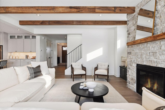 living room with beamed ceiling, a fireplace, and dark wood-type flooring