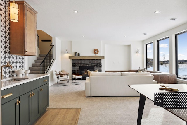 living room featuring a water view, light colored carpet, and a brick fireplace