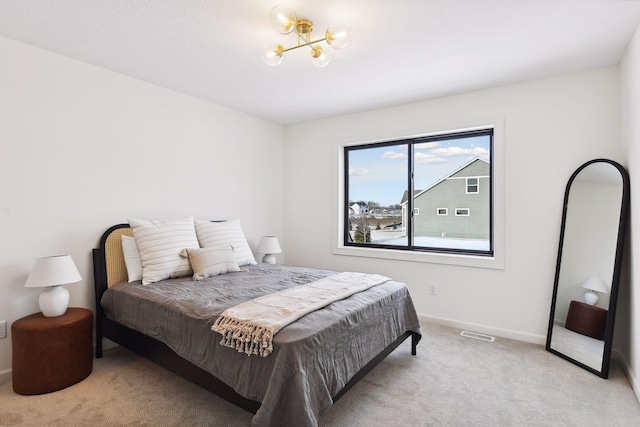 bedroom with light carpet and a chandelier