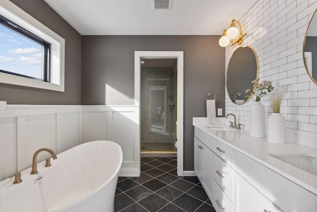 bathroom with tile patterned flooring, vanity, and plus walk in shower