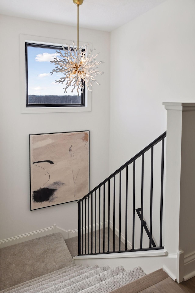 stairway featuring carpet and an inviting chandelier