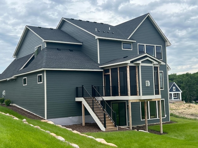 rear view of property featuring a yard and a sunroom