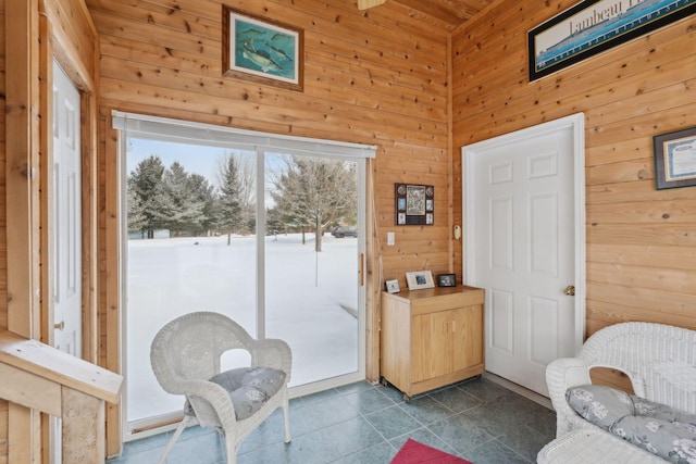 interior space featuring a wealth of natural light, dark tile patterned floors, and wood walls