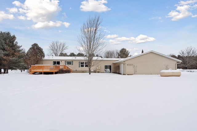 snow covered back of property featuring a wooden deck