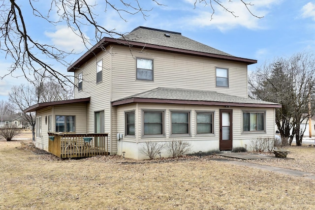 rear view of property featuring a wooden deck and a yard