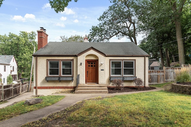 bungalow-style home featuring a front yard