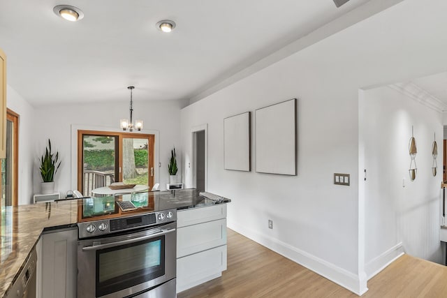 kitchen with wall oven, decorative light fixtures, light hardwood / wood-style flooring, dark stone countertops, and a chandelier