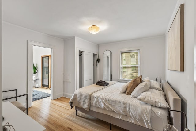 bedroom featuring crown molding and light wood-type flooring