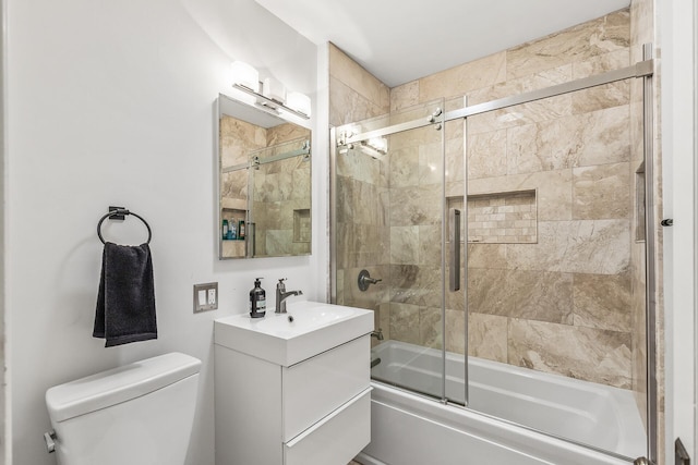 full bathroom featuring vanity, bath / shower combo with glass door, and toilet