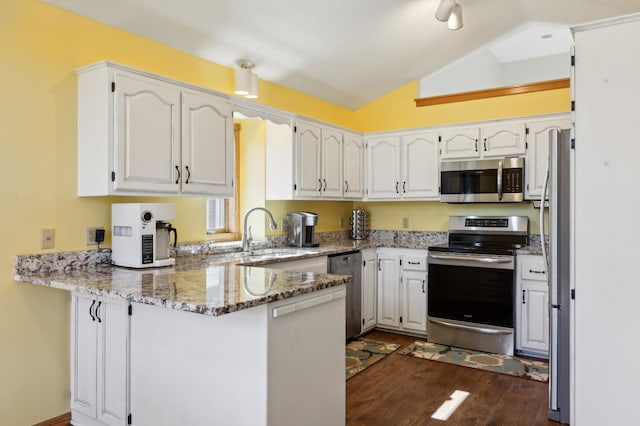 kitchen featuring white cabinetry, stone counters, lofted ceiling, kitchen peninsula, and appliances with stainless steel finishes