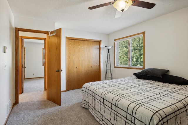 carpeted bedroom with a textured ceiling and ceiling fan